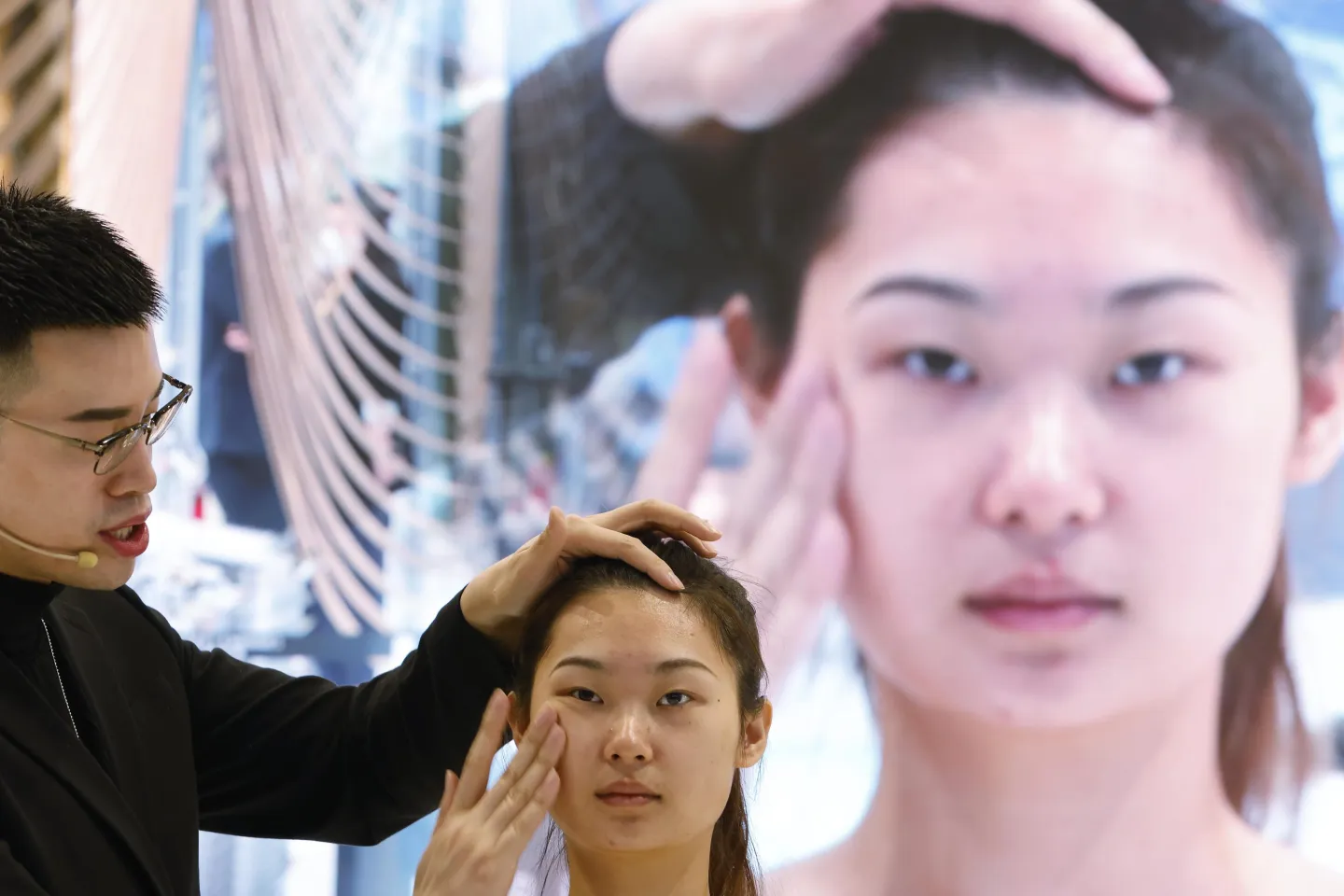 A staff member applies makeup to a model at the Estee Lauder booth in Shanghai